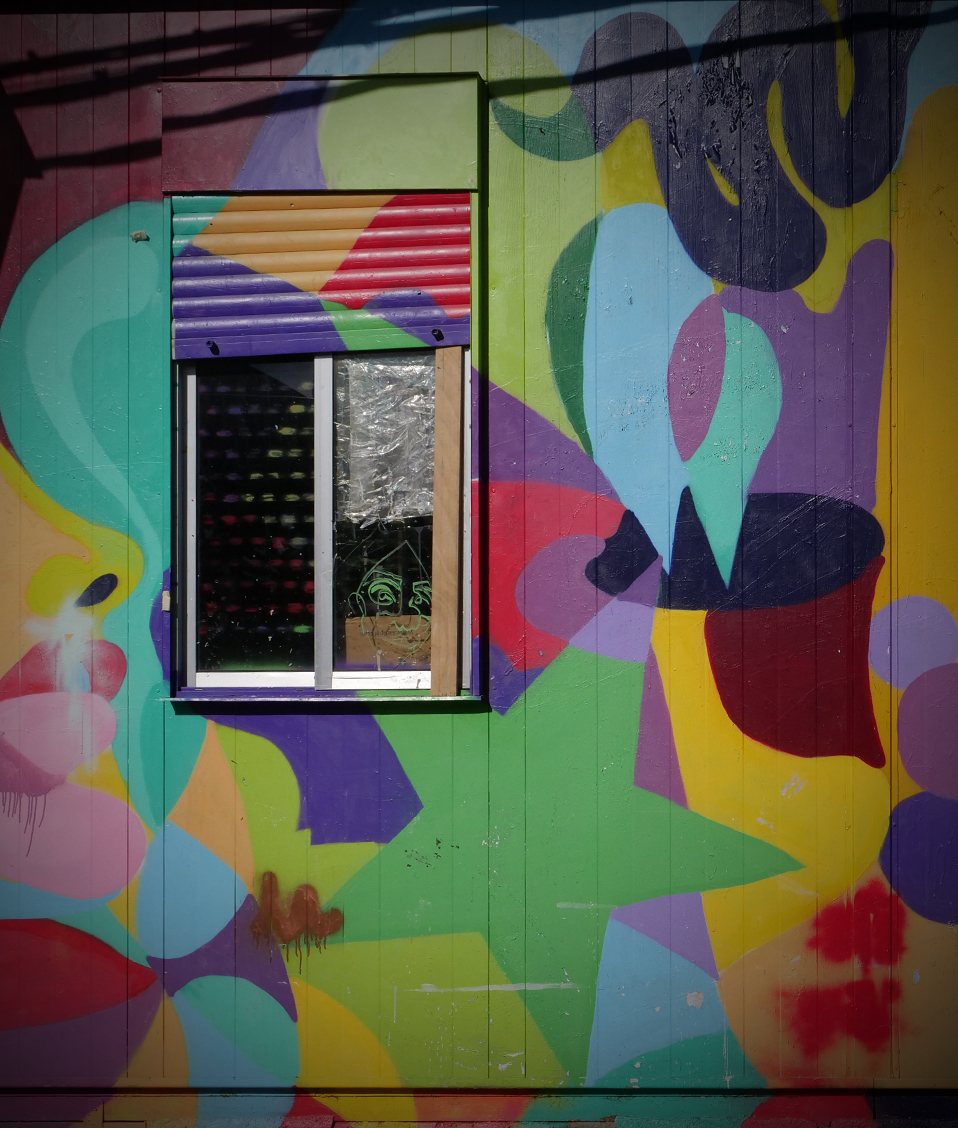 Exterior de una instalación de la Facultad de Bellas Artes con la pared llena de dibujos coloridos