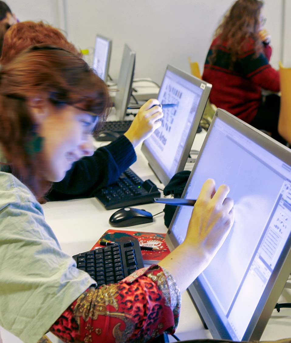 Alumna dibujando en una tableta gráfica en un aula de la Facultad de Bellas Artes