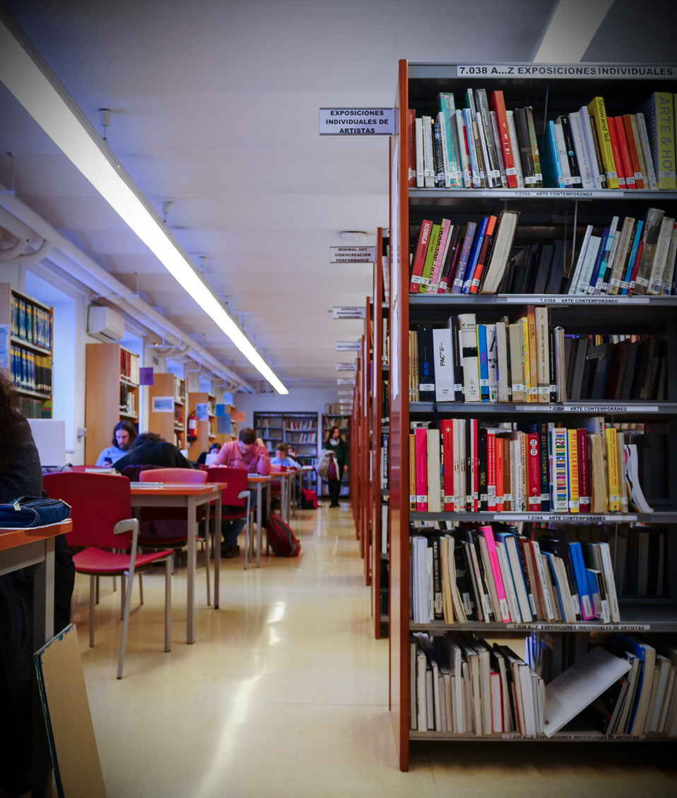 Biblioteca de la Facultad de Bellas Artes con alumnos estudiando y estanterías con libros a la derecha