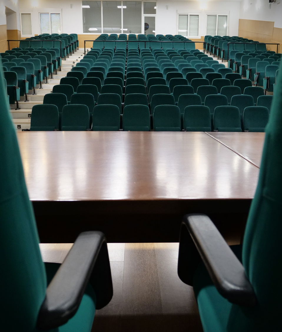 Salón de actos vacío de la Facultad de Ciencias del Deporte visto desde la tarima principal