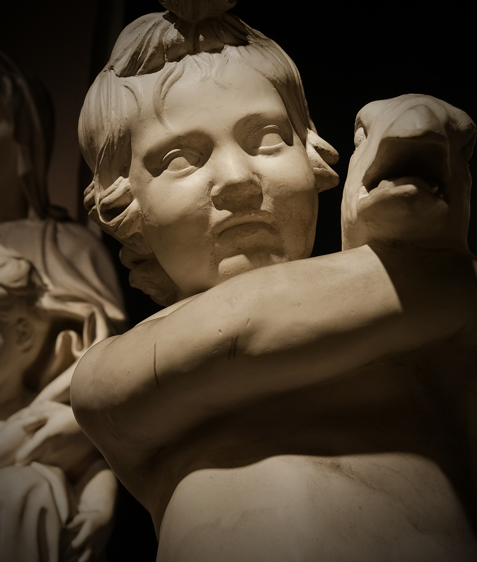 Escultura de un niño con un ganso y al fondo otra de una mujer y con su hijo